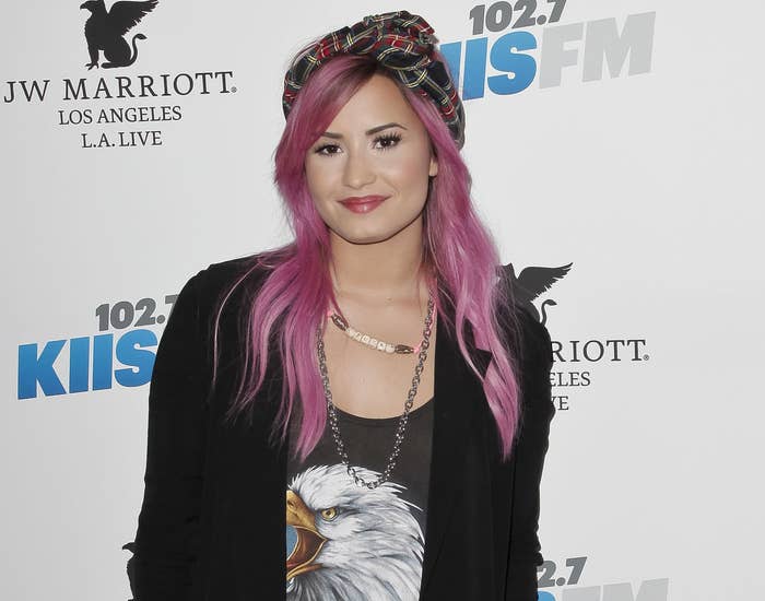 Demi looks casual in a graphic tank and cardigan with pink hair