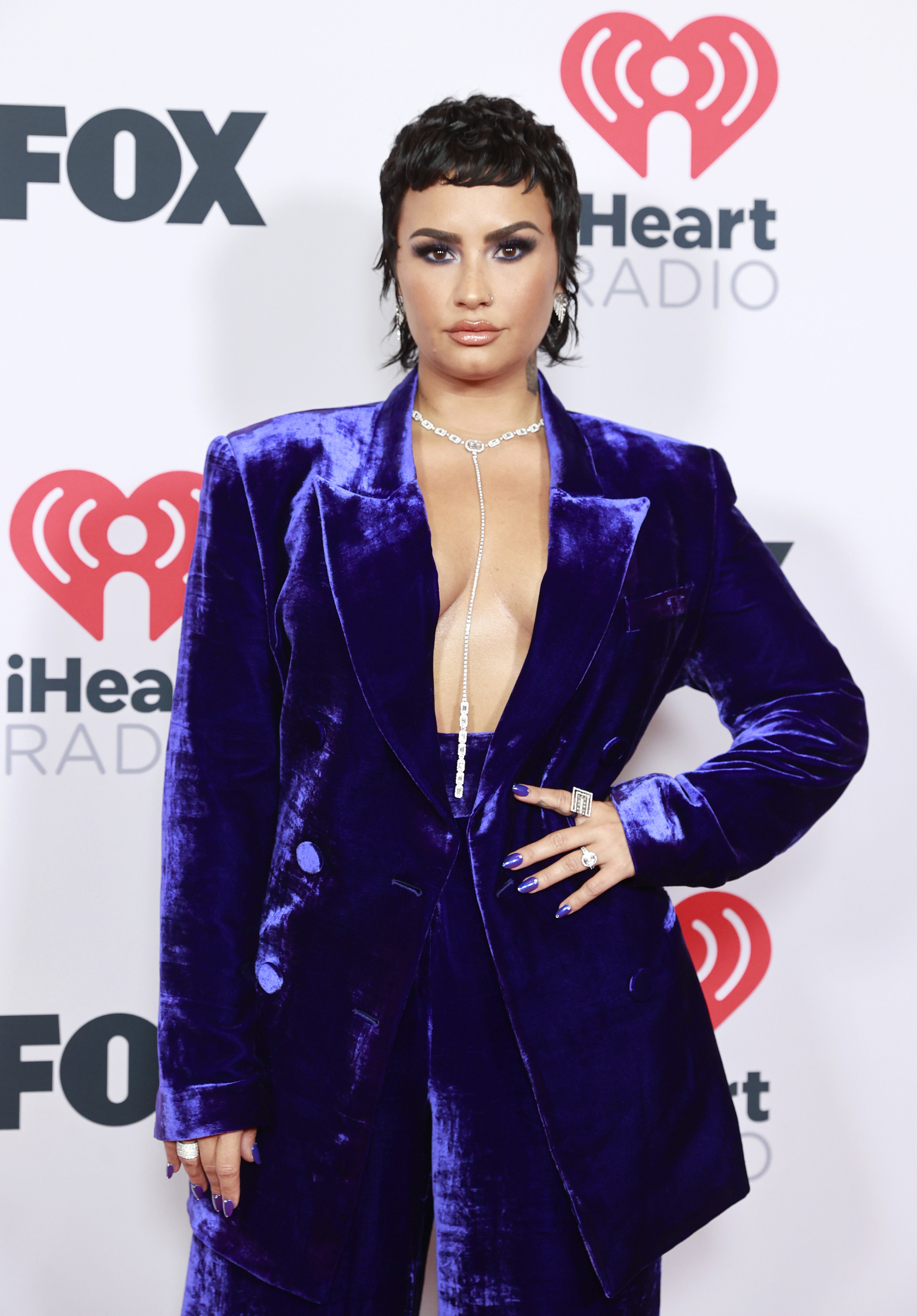 Demi wears a purple velvet blazer while showing off a new mullet hairstyle