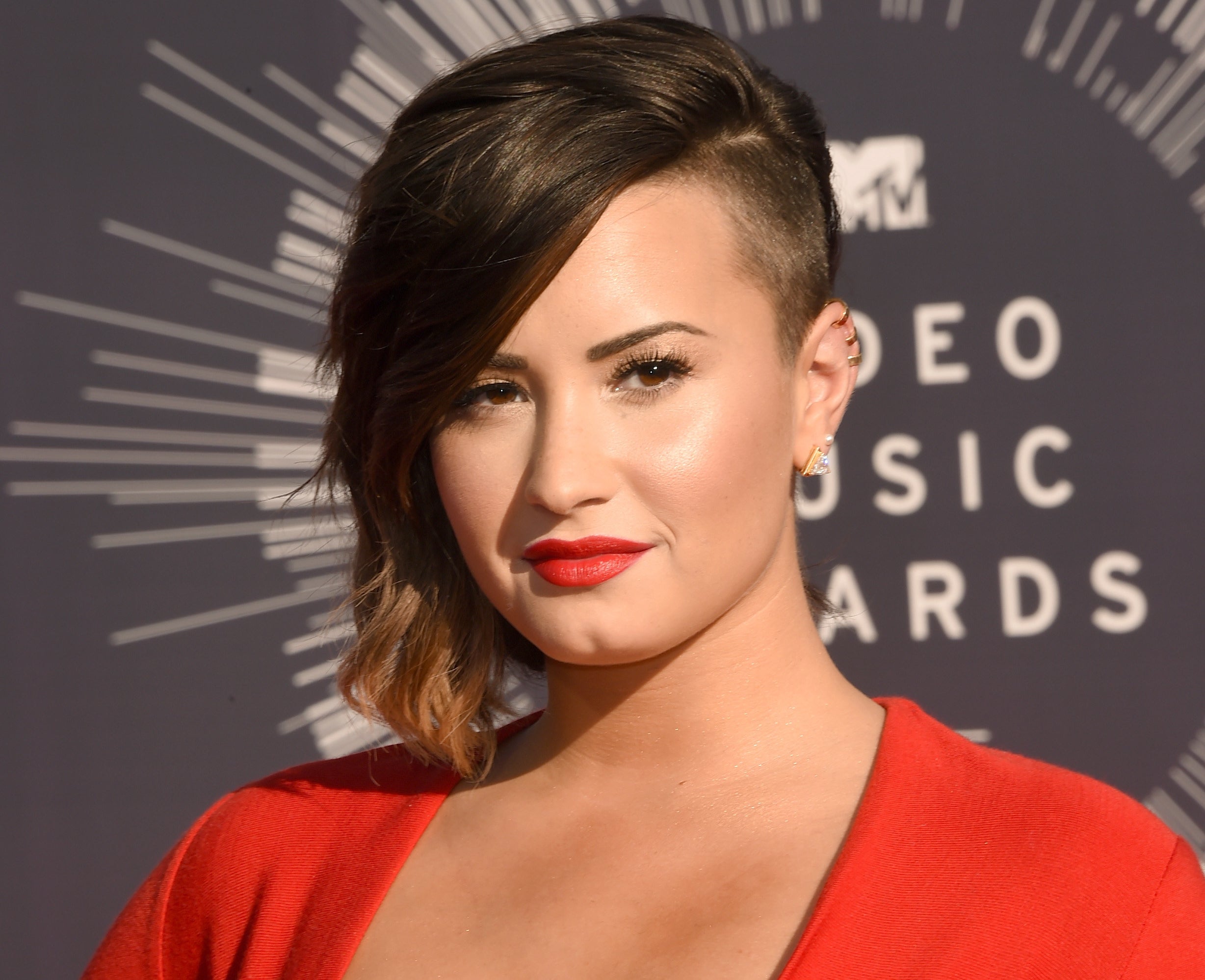 Demi attends an event showing off their shaved side