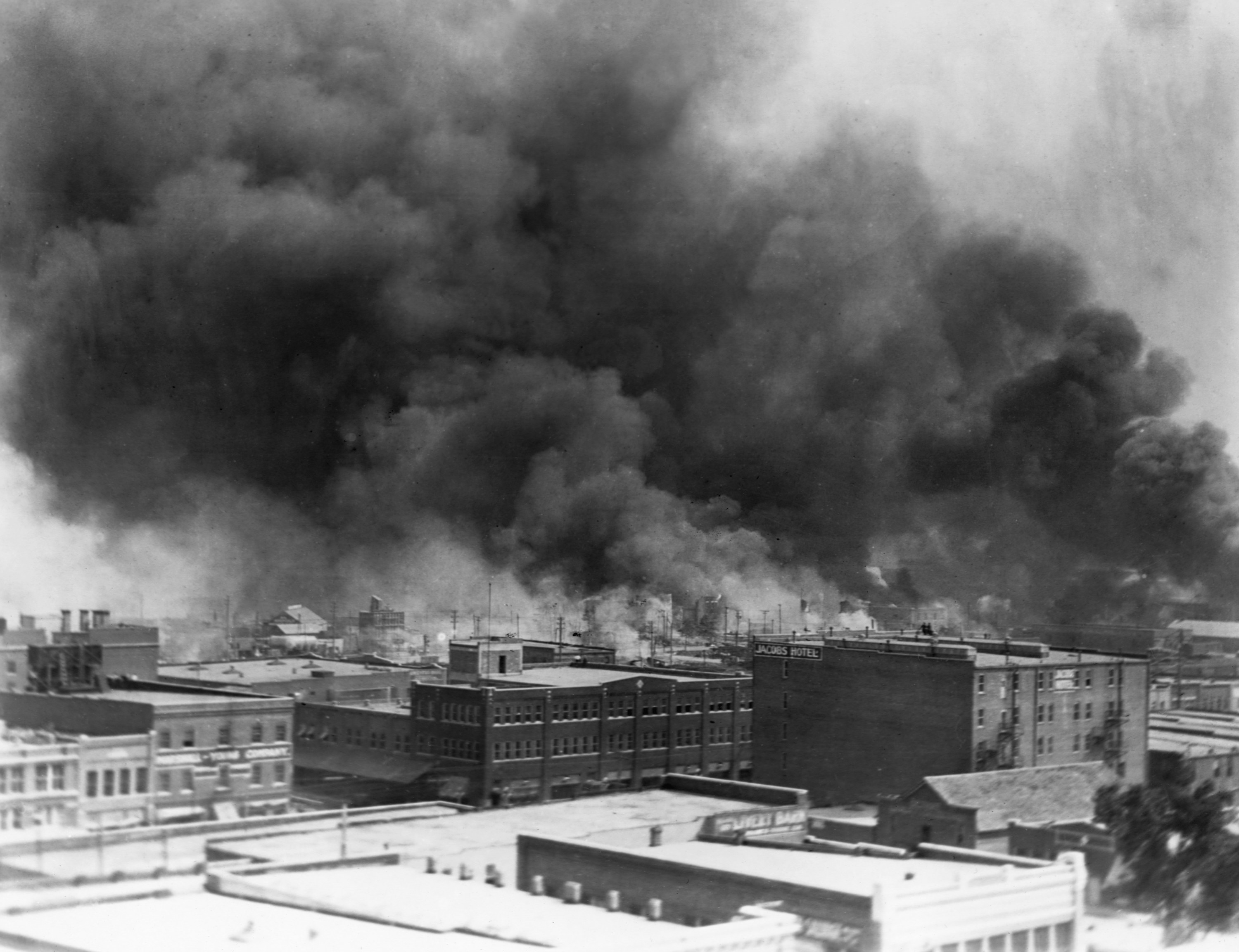 Black smoke billows from fires during the Tulsa massacre in the Greenwood District, June 1921