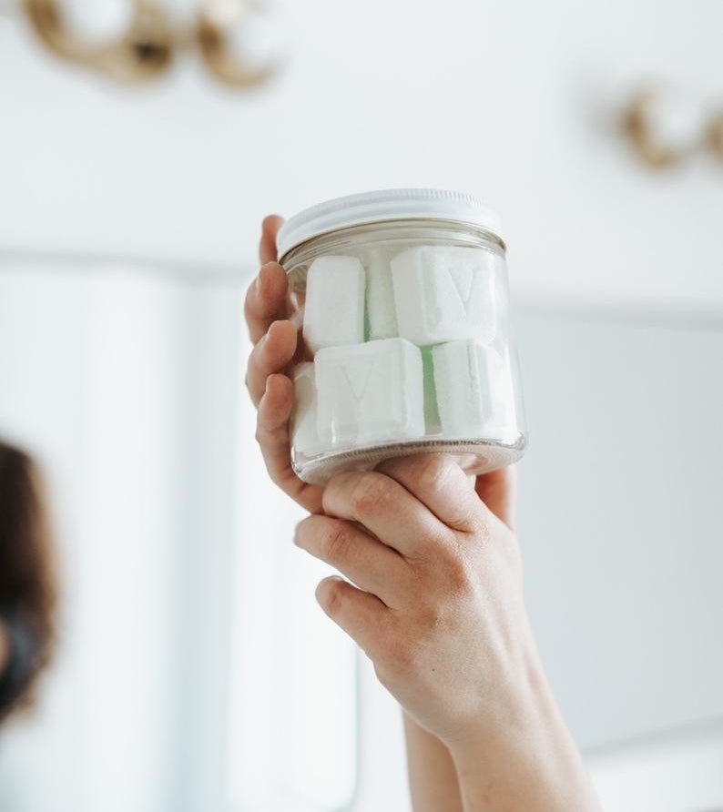 a product shot of someone holding the jar of toilet bombs