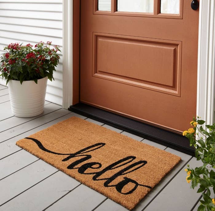 a brown doormat with script reading "hello"