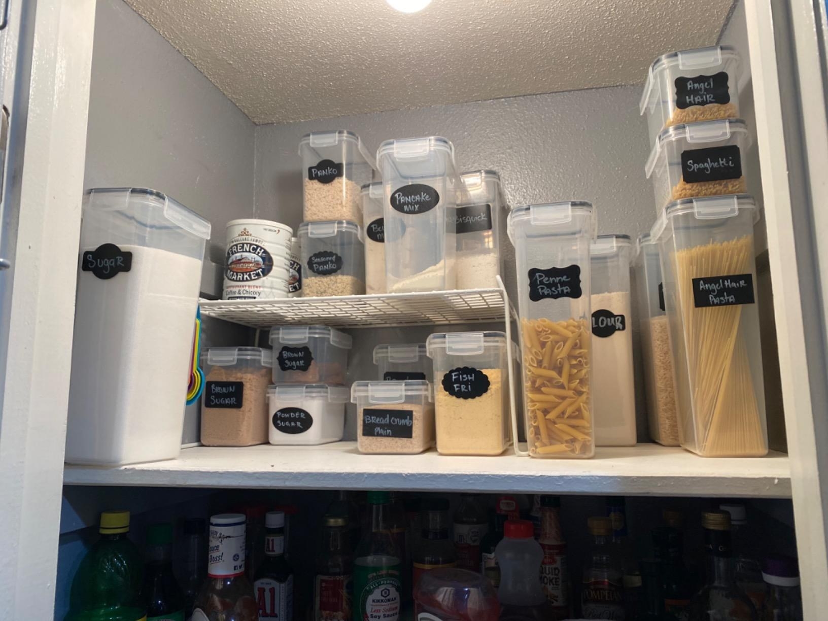 The food storage containers of various sizes, with labels, inside a pantry