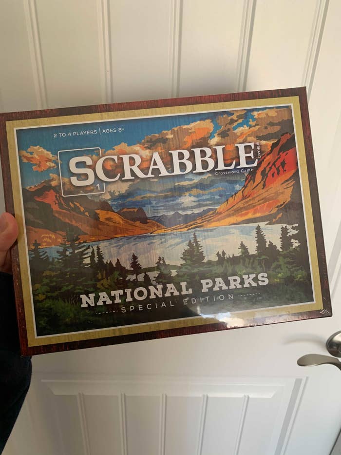 A person holding up the box for the game