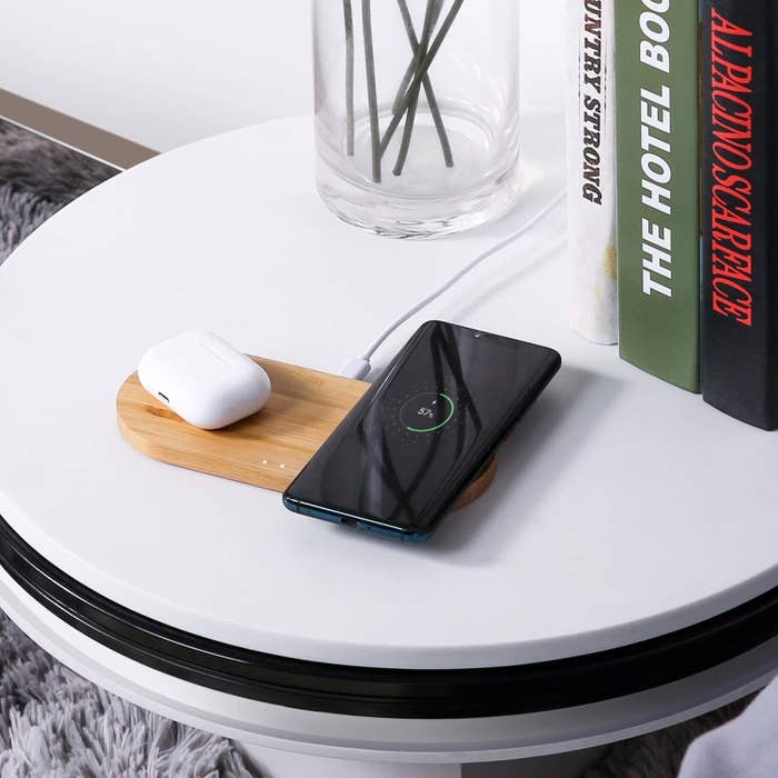 A phone and AirPods on the charging pad