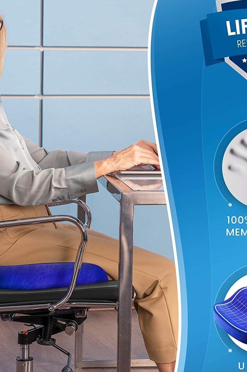A person sitting on a computer chair in front of their desk with a memory foam cushion underneath them