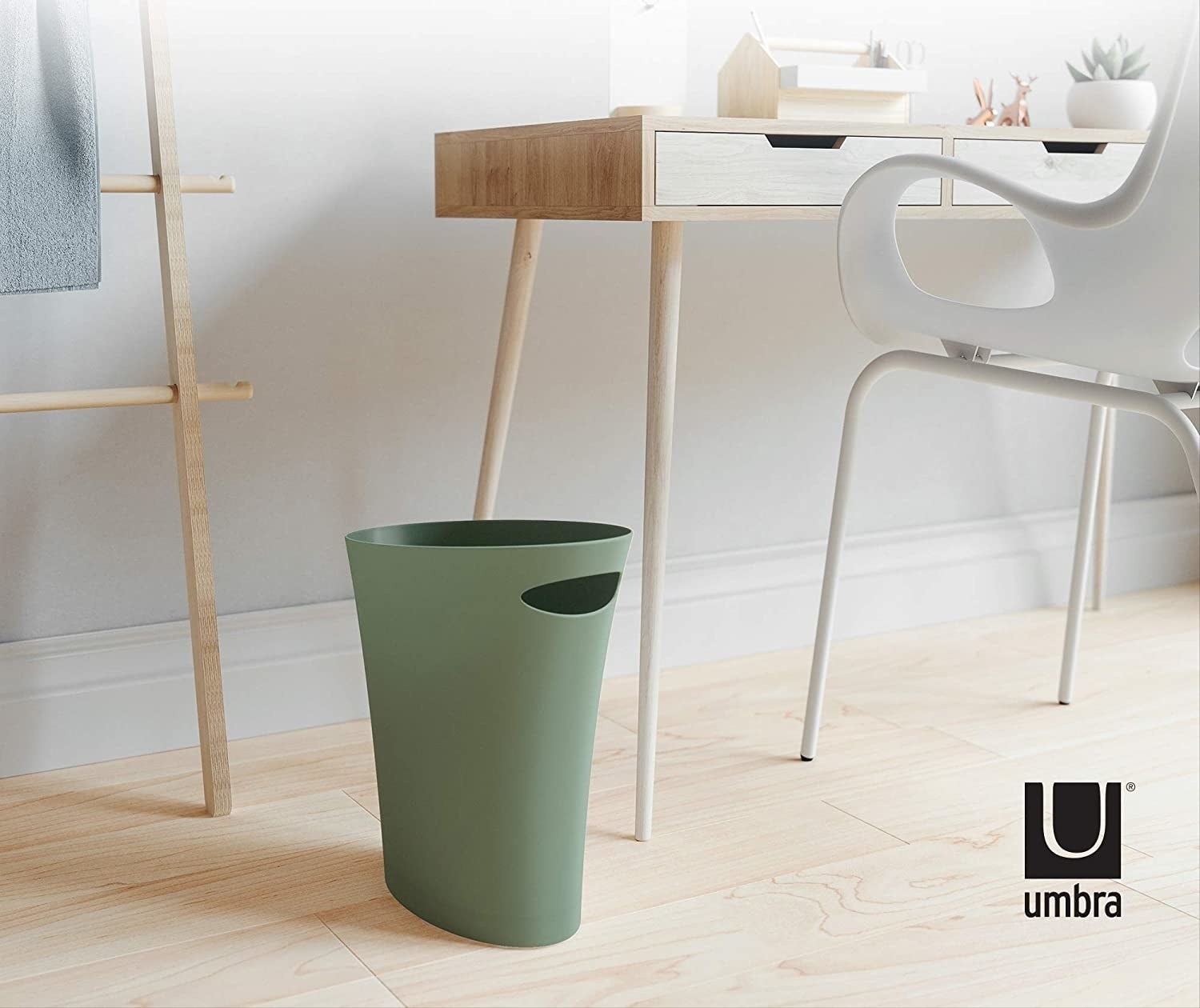 A small trash can beside a desk
