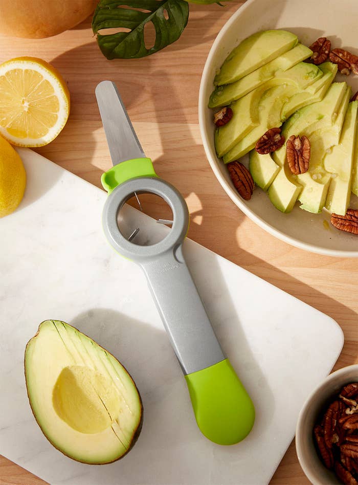 A flatlay of the tool next to a sliced avocado