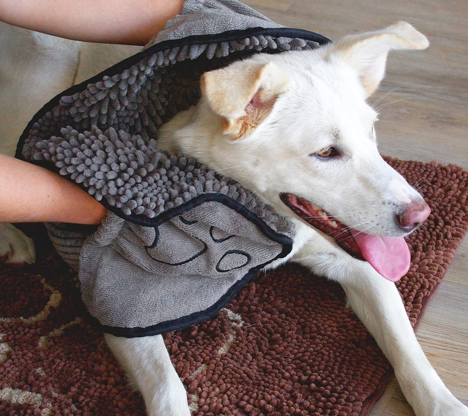a model using the gray shammy towel on a white dog 