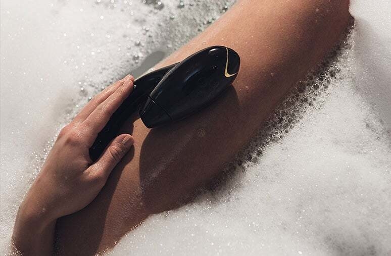 Sucking and insertable toy placed on model&#x27;s leg inside bubble bath 