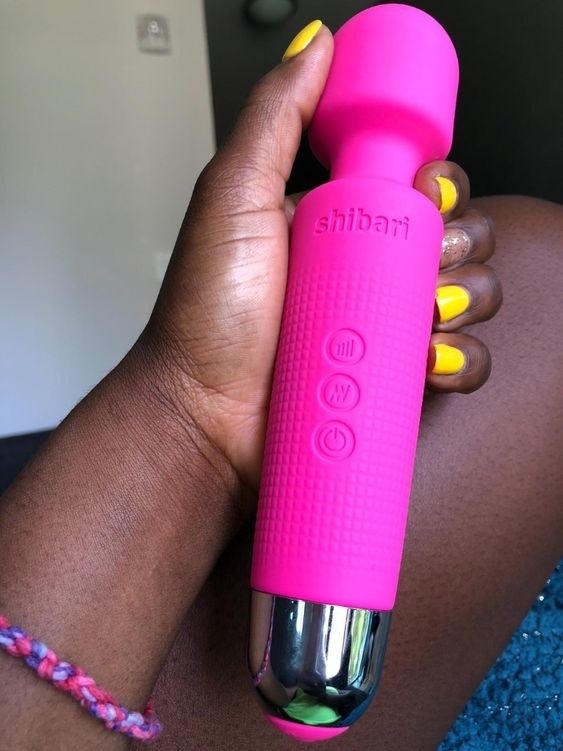 Reviewer holding the wand-like vibrator 