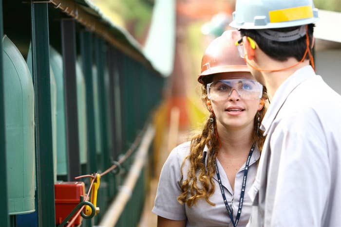 A woman speaking to a man at an Iron Ore Production site in the State of Minas Gerais, Brazil