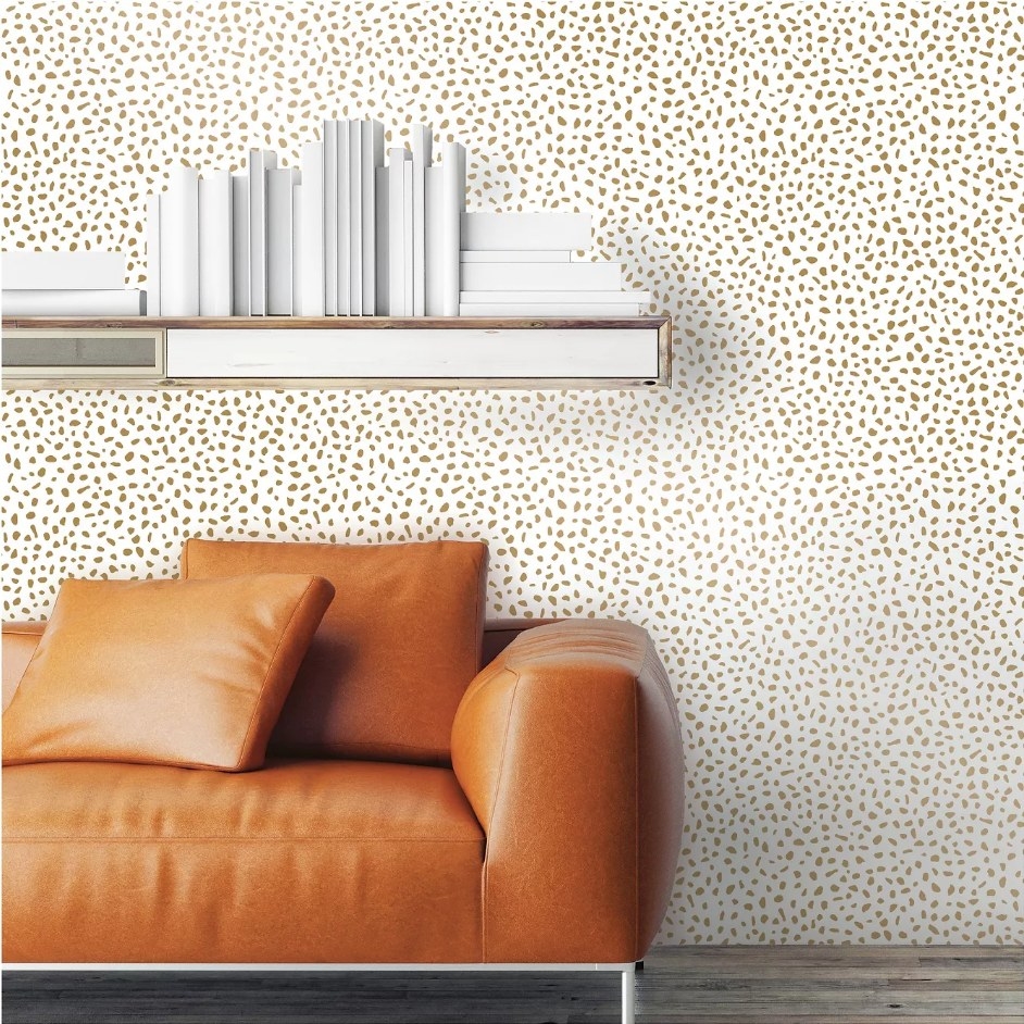 A gold and white, speckled dot, peel and stick wallpaper displayed in a living room 