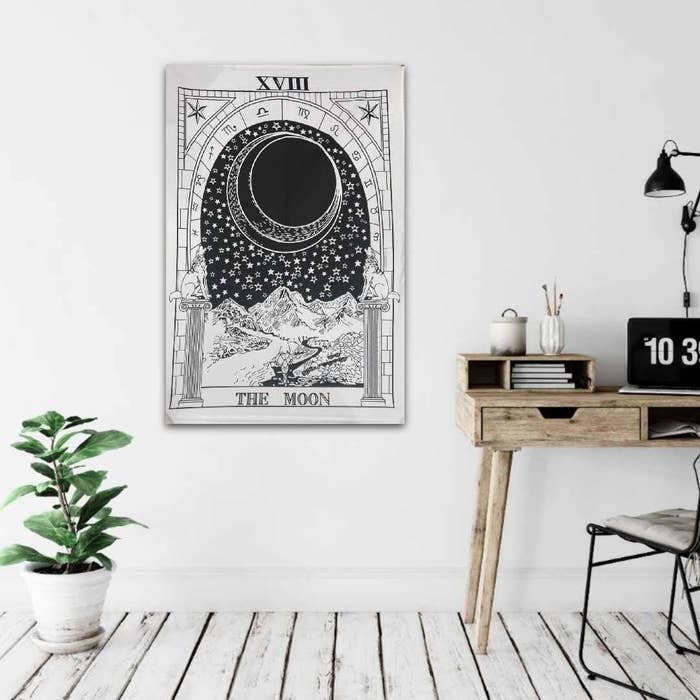 A tarot card-inspired Moon tapestry on wall.