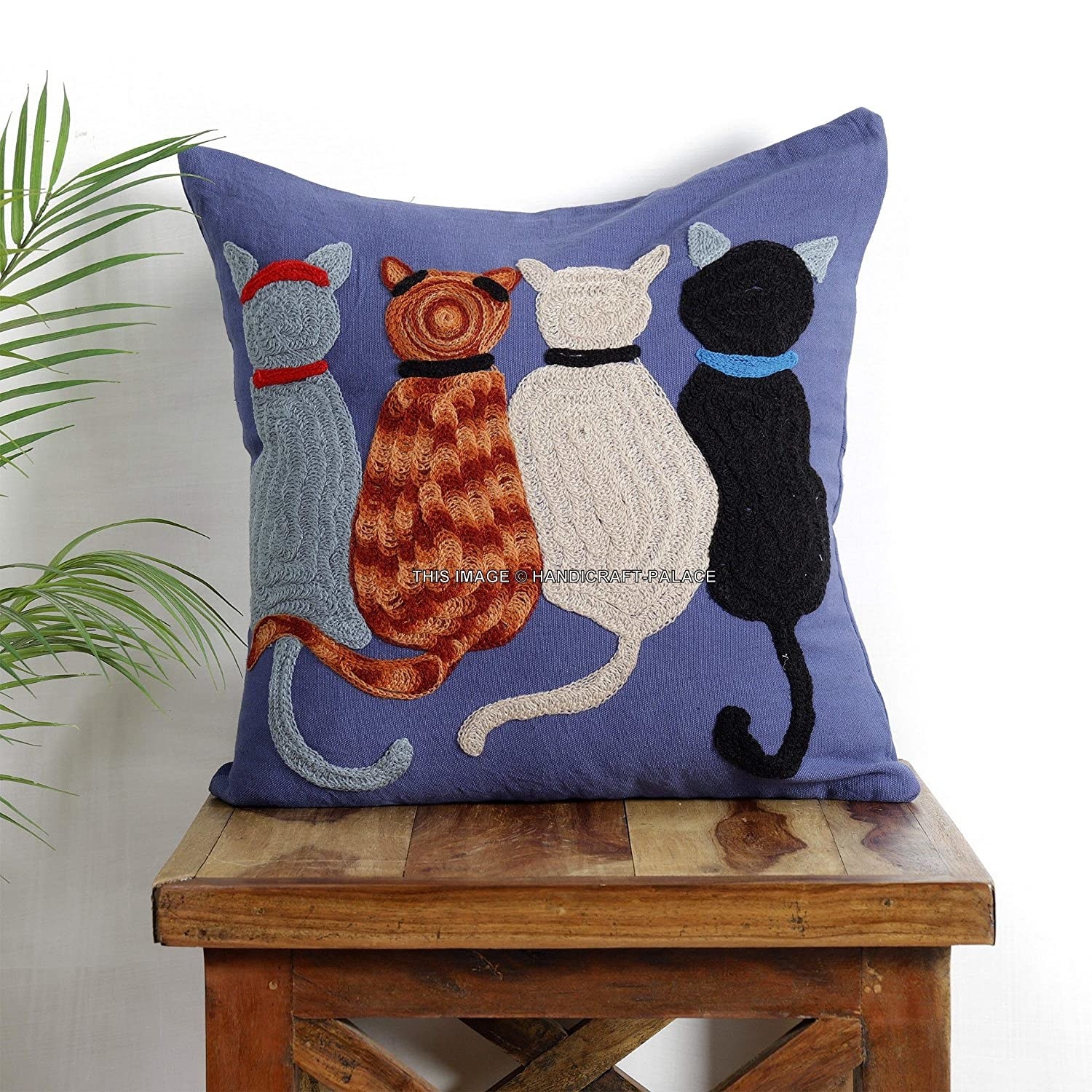 Blue embroidered cat cushion with four cats