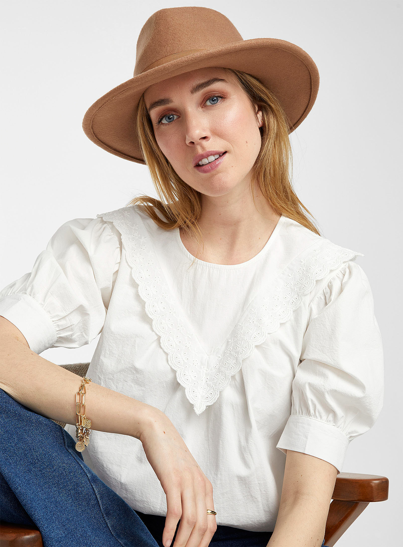 A person wearing a blouse with jeans