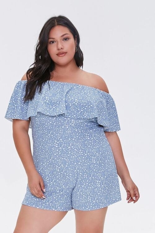 Model wearing blue romper with white spots with wavy fabric across shoulder area