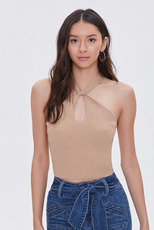 Model wearing dark cream top with textured sweater material, stops at waist
