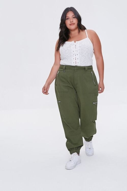 Model wearing army green jogger with silver zipper, cuffed with elastic at the ankles