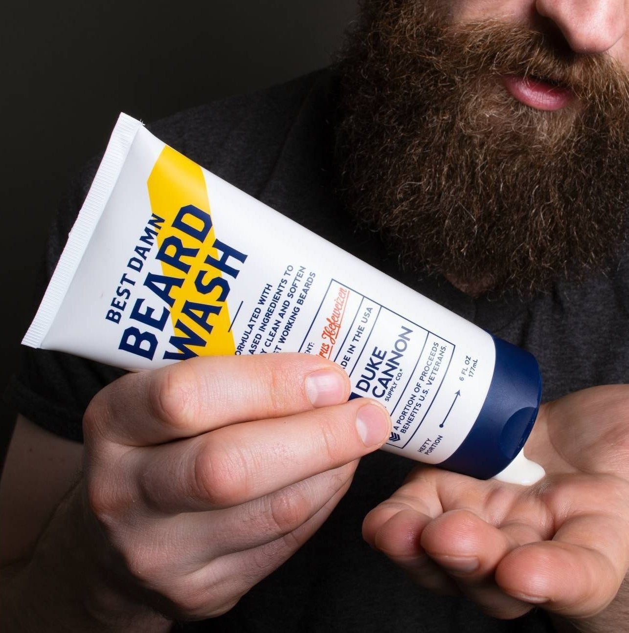 a model squeezing the beard wash into their hand