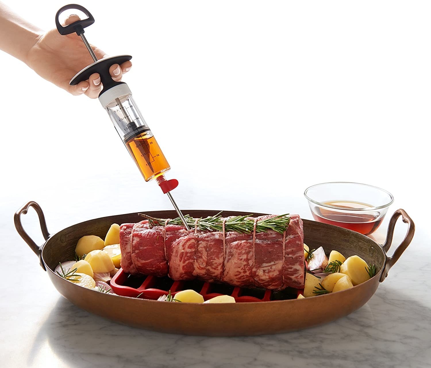person injecting a piece of meat with the injector