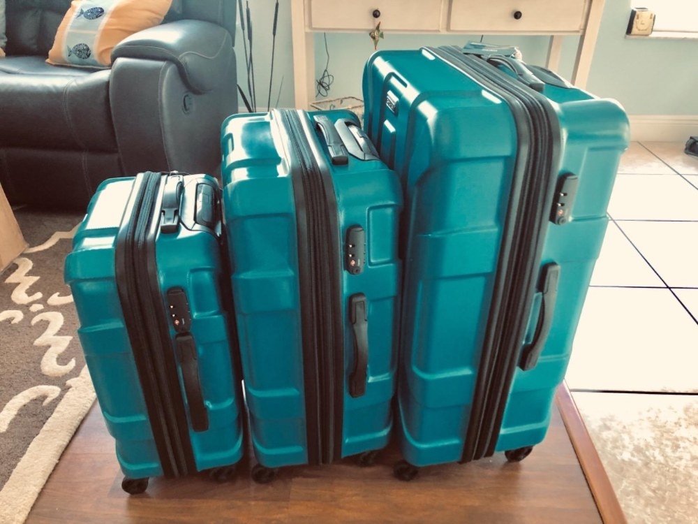 Reviewer&#x27;s photo of the suitcase in multiple sizes in the color Caribbean Blue