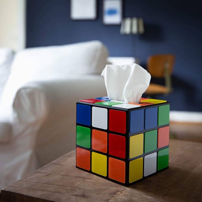 the getDigital plastic magic cube tissue box cover over a box of tissues on a wooden desk