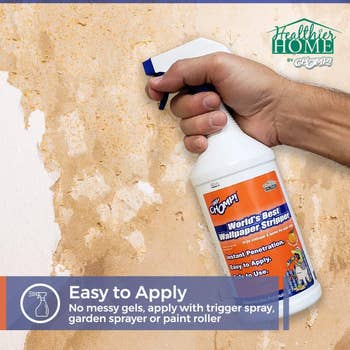 The wallpaper remover spray being used on a wall