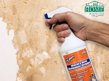 The wallpaper remover spray being used on a wall