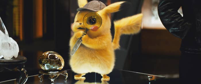 Detective Pikachu looking through a magnifying glass 