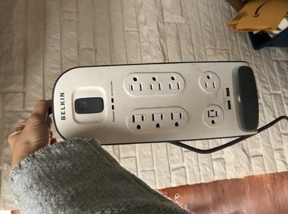 a reviewer holding the white power strip