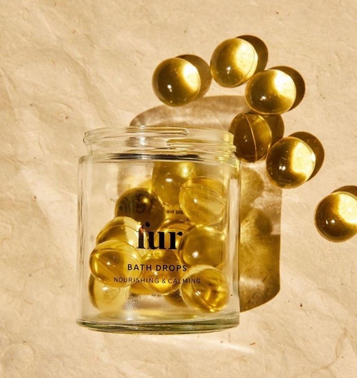 A small glass jar that is filled with large round beads