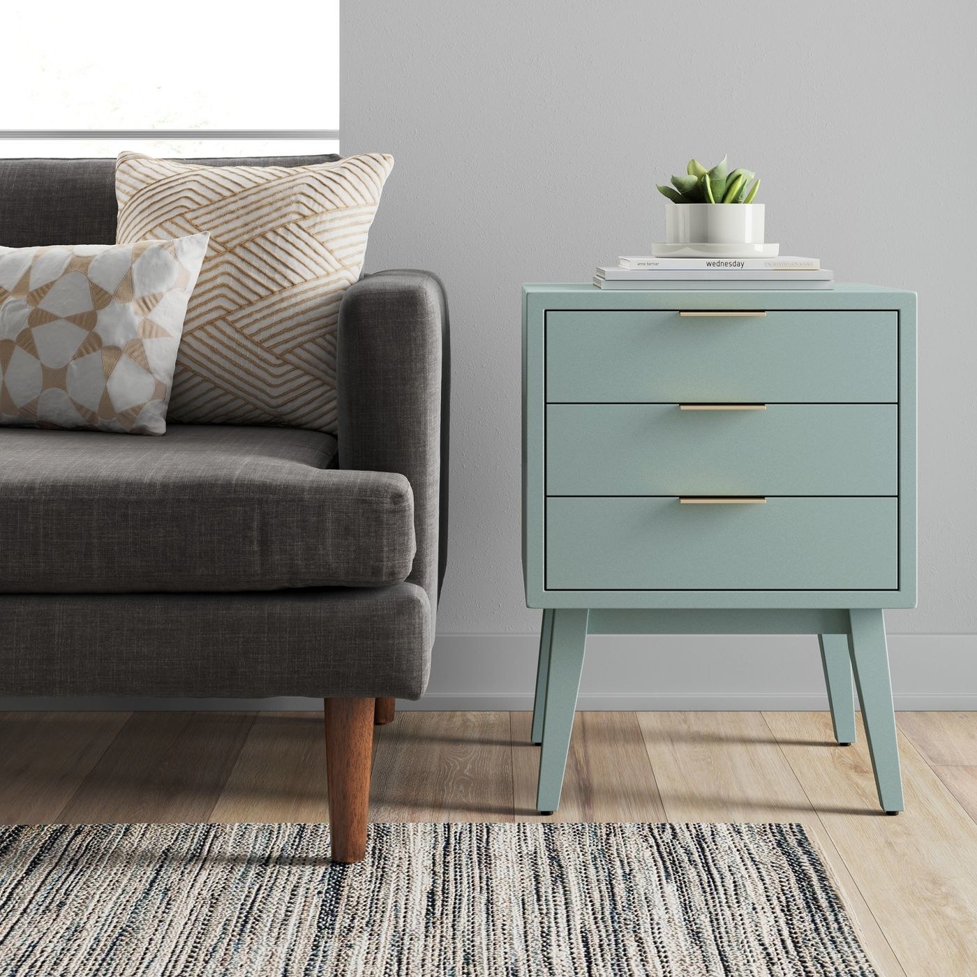 A three drawer end table next to a couch