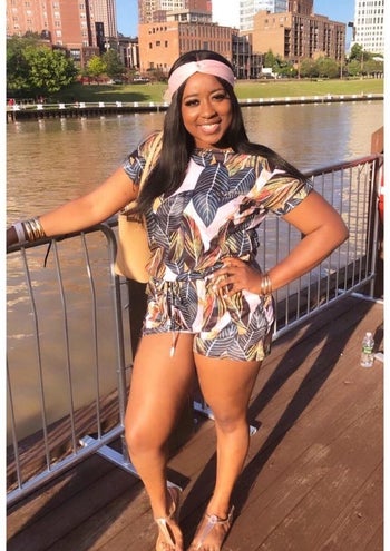 a reviewer wearing the romper in a palm print with heels