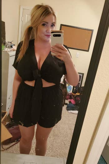 front view of a reviewer wearing the tie-front romper in black