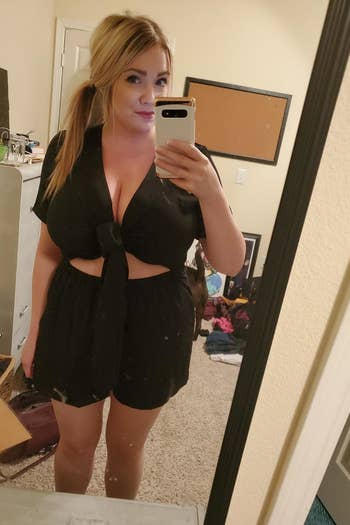 front view of a reviewer wearing the tie-front romper in black