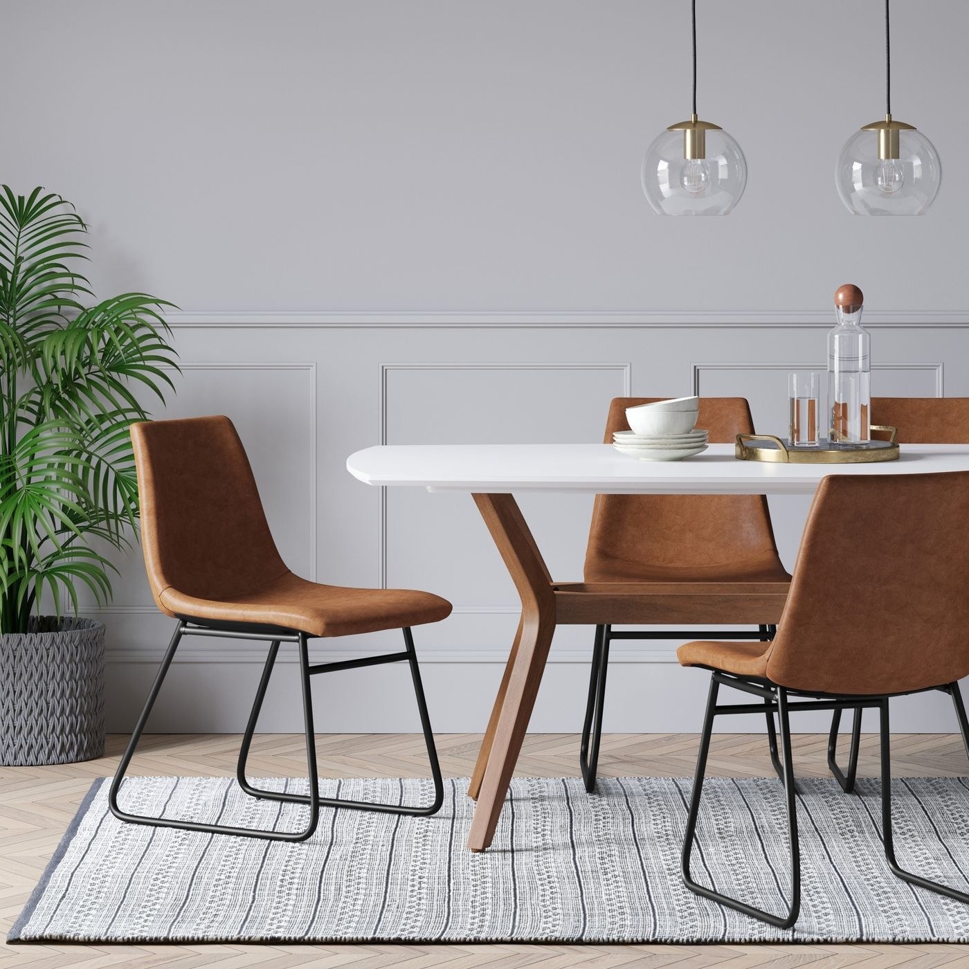 A set of faux leather and metal dining chairs around a table