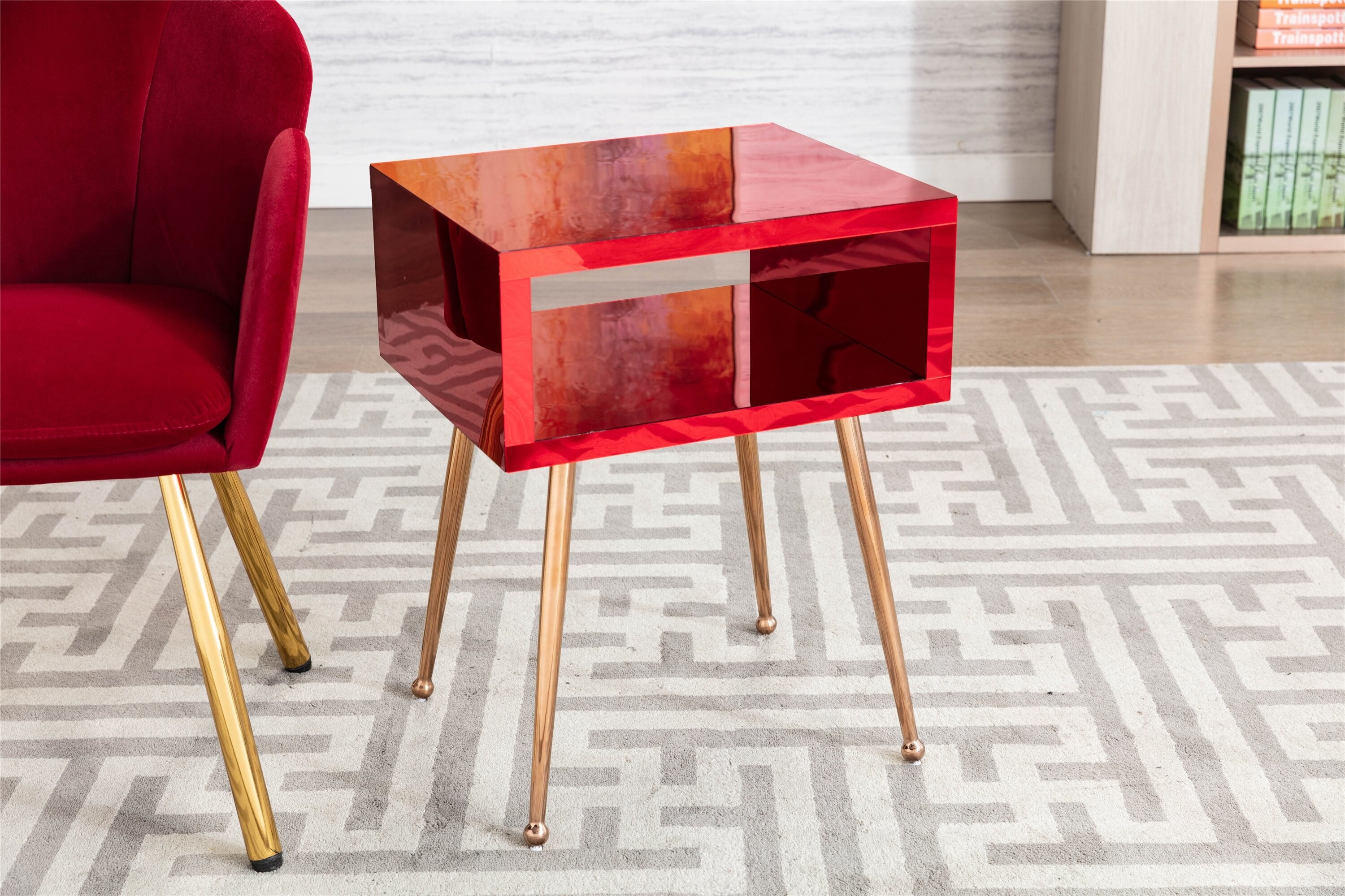 the red corrigan studio maaria stainless steel nightstand next to a red armchair