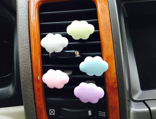 Little cloud-shaped clips in pastel colors attached to a car's vent 