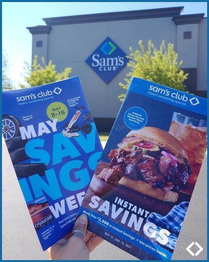 A model holding two Sam&#x27;s Club flyers