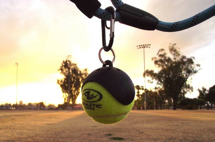 plastic semi circle with tennis ball wedged in it on a keychain 