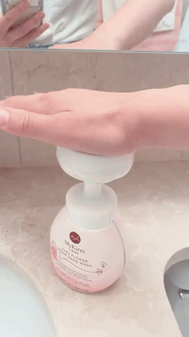 Editor using the dispenser to put the soap on their hand 