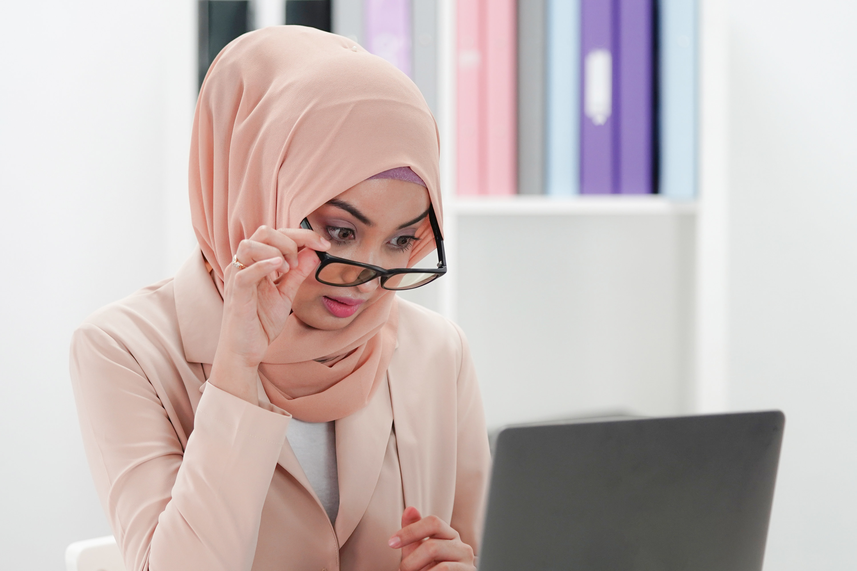 Photo of a woman looking concerned at a computer