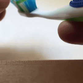 The Baby Yoda topper dispensing toothpaste onto a brush through its mouth 