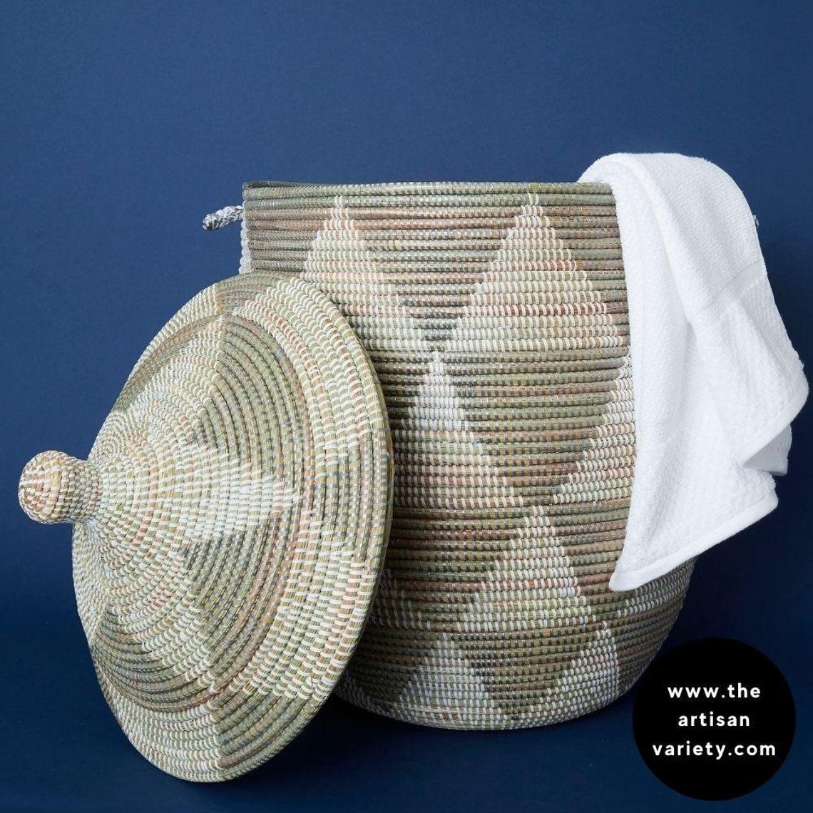 lidded triangle-pattern woven basket with towel hanging off of side