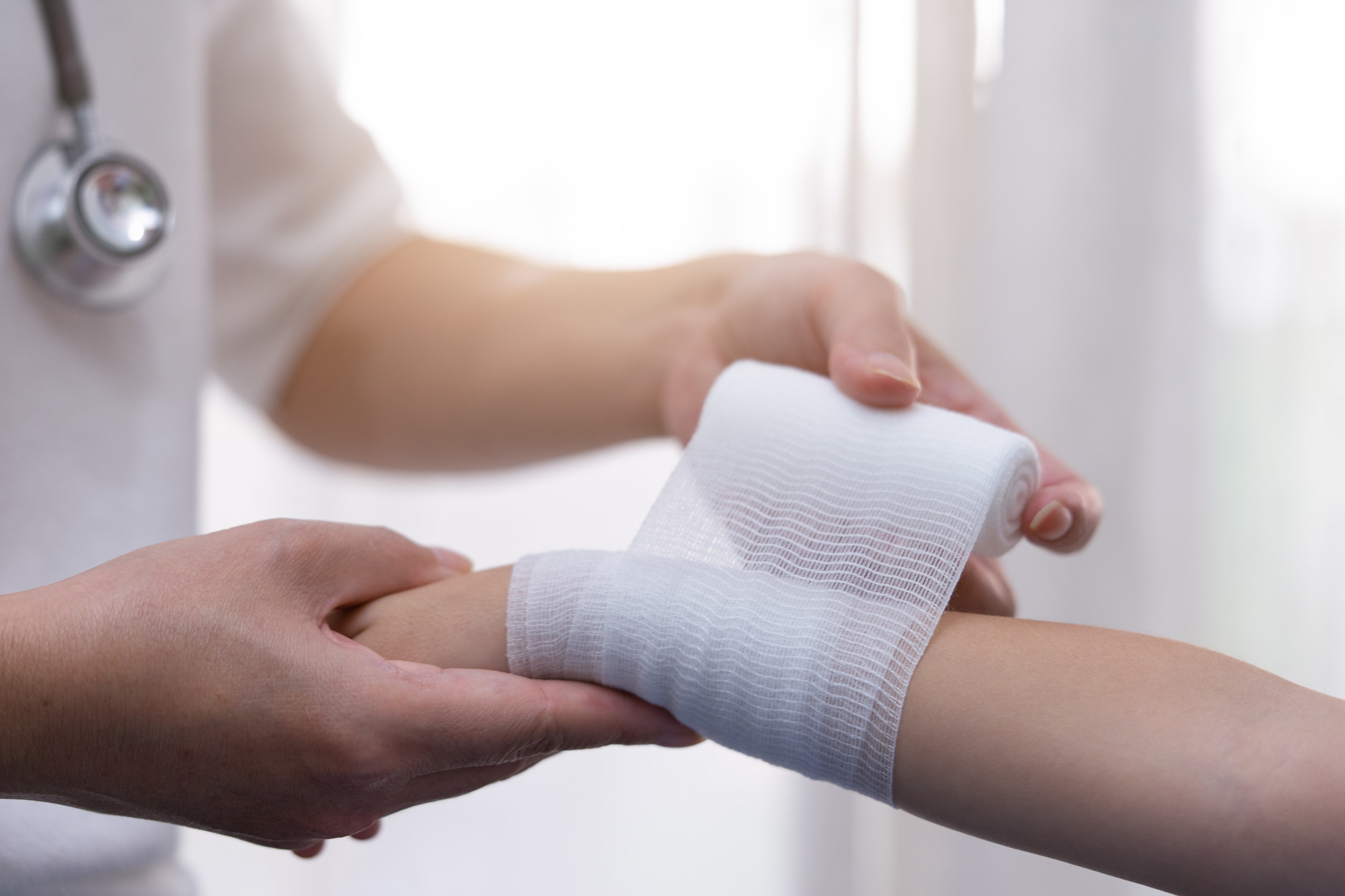 Photo of a doctor wrapping a child&#x27;s arm in a bandage