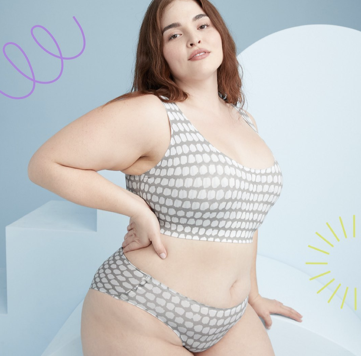 Model wearing gray with white abstract polka dot print underwear and bra  