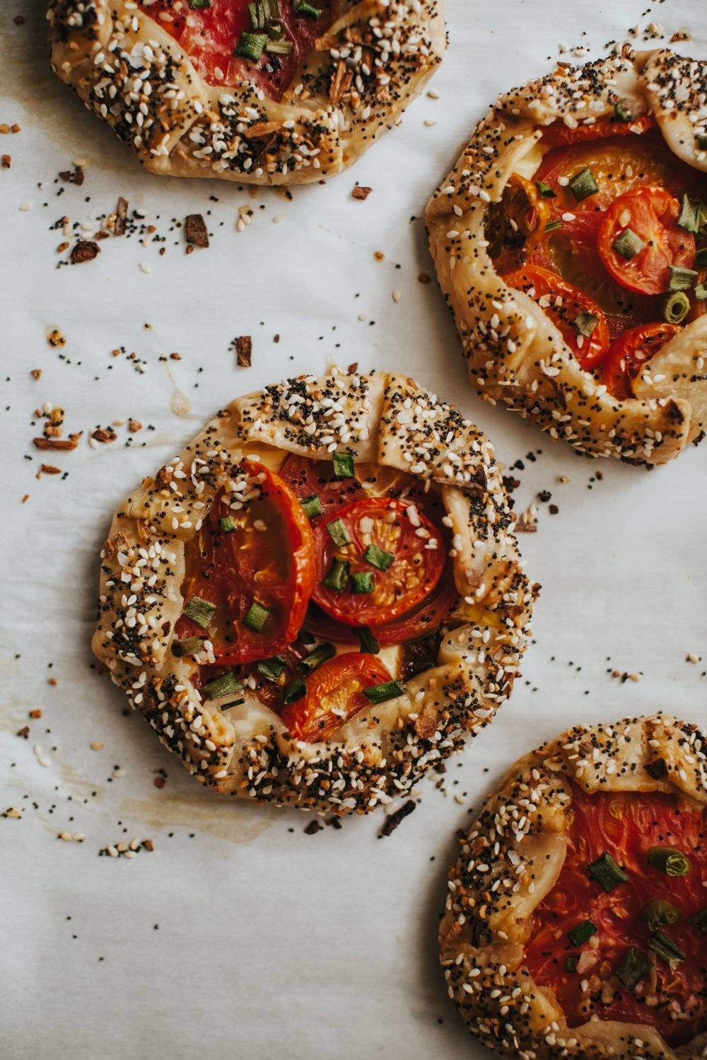 Everything bagel galettes with tomatoes and scallions.