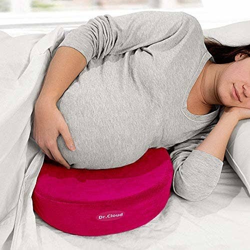 Pregnant women resting her stomach on the maternity pillow and sleeping.