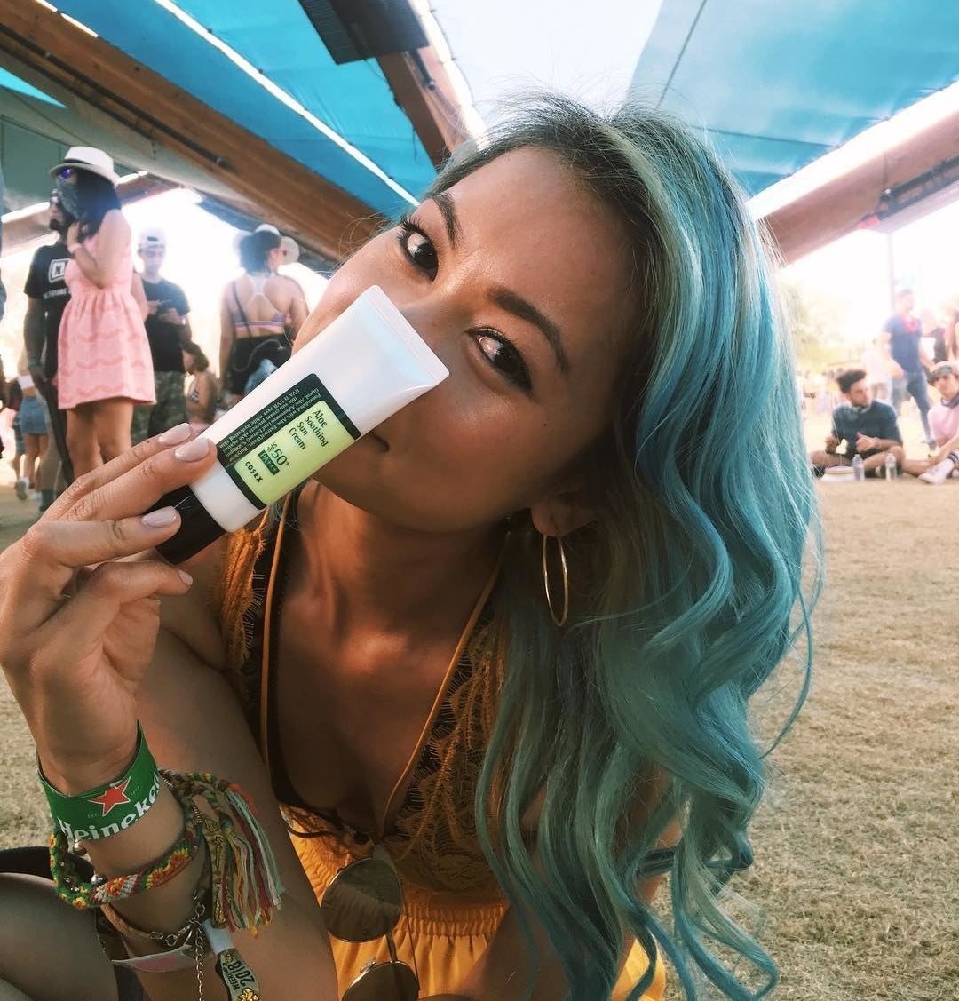 A person holding the sunscreen up to their face
